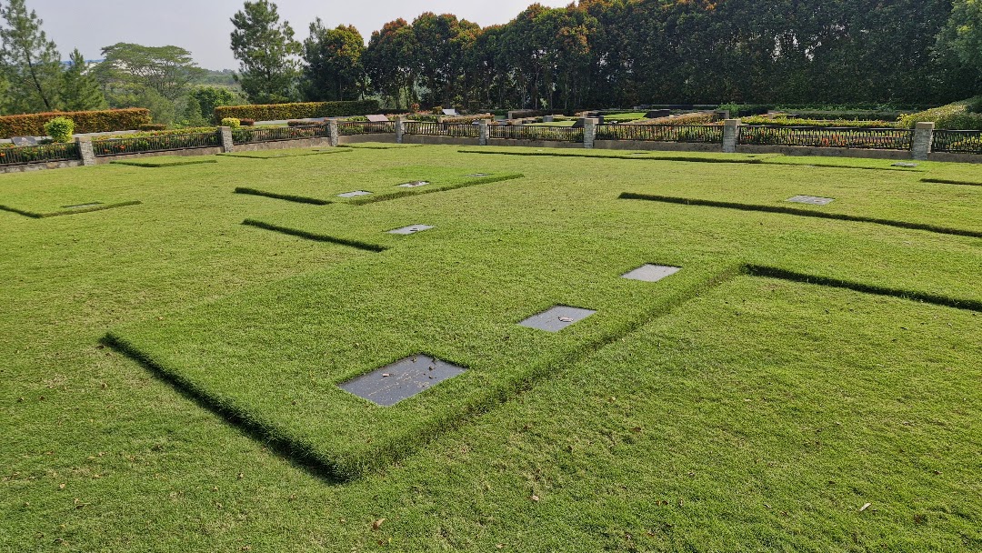 Lahan Single Burial di Serenity San Diego Hills berjajar di atas rumput hijau, dikelilingi pagar besi dan pilar batu