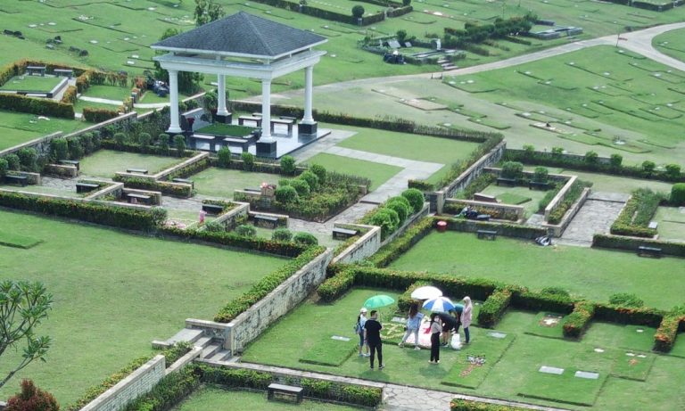 Suasana taman pemakaman San Diego Hills yang asri, dengan pavilion dan keluarga berziarah
