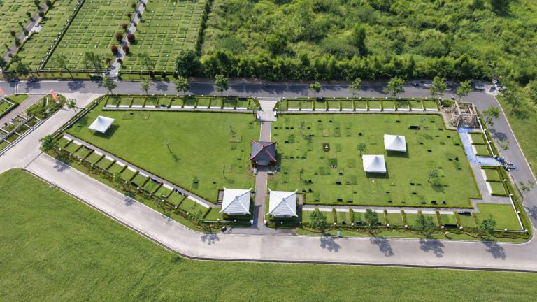 Foto udara area Ruby Mansion di San Diego Hills: taman makam Chinese yang tertata rapi dengan bangunan beratap merah di tengah dan jalan lingkungan yang lebar