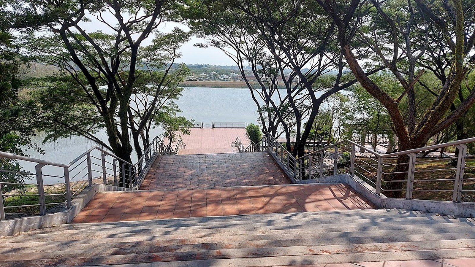 Dermaga dan tangga menuju tepi danau San Diego Hills di bawah pepohonan rindang