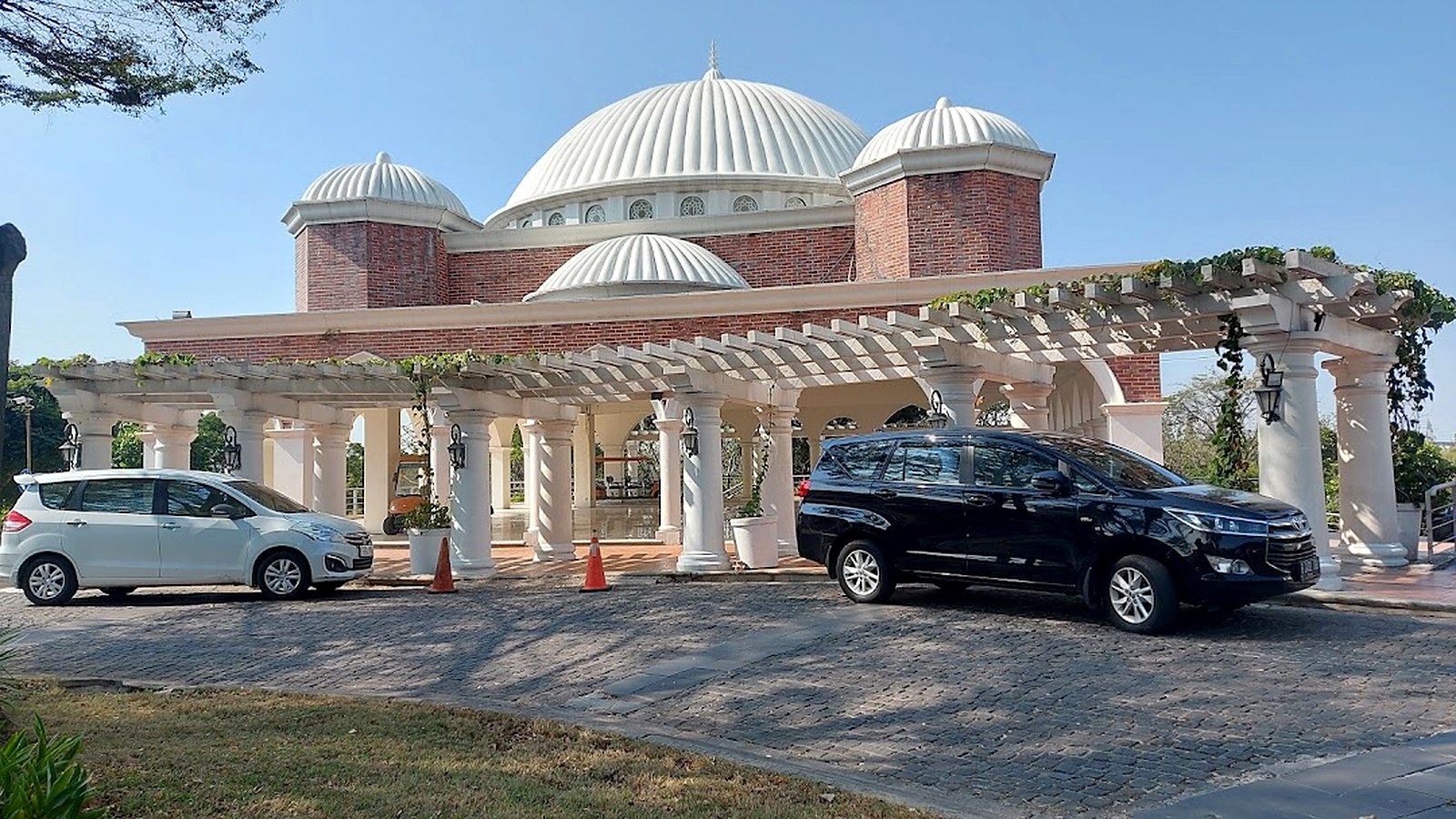 Heavenly Dome San Diego Hills, gedung serbaguna berkubah putih untuk menjamu pelayat dan acara keluarga, dengan pergola dan area parkir di depannya