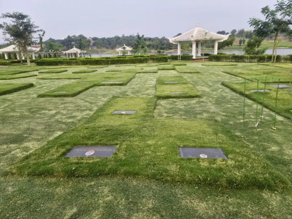 Hamparan makam Cherry Blossom Garden San Diego Hills di depan danau dengan paviliun putih dan rumput hijau